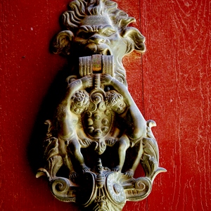 heurtoir élégant représentant deux enfants accroché à une tête de lion sur porte rouge - France  - collection de photos clin d'oeil, catégorie portes